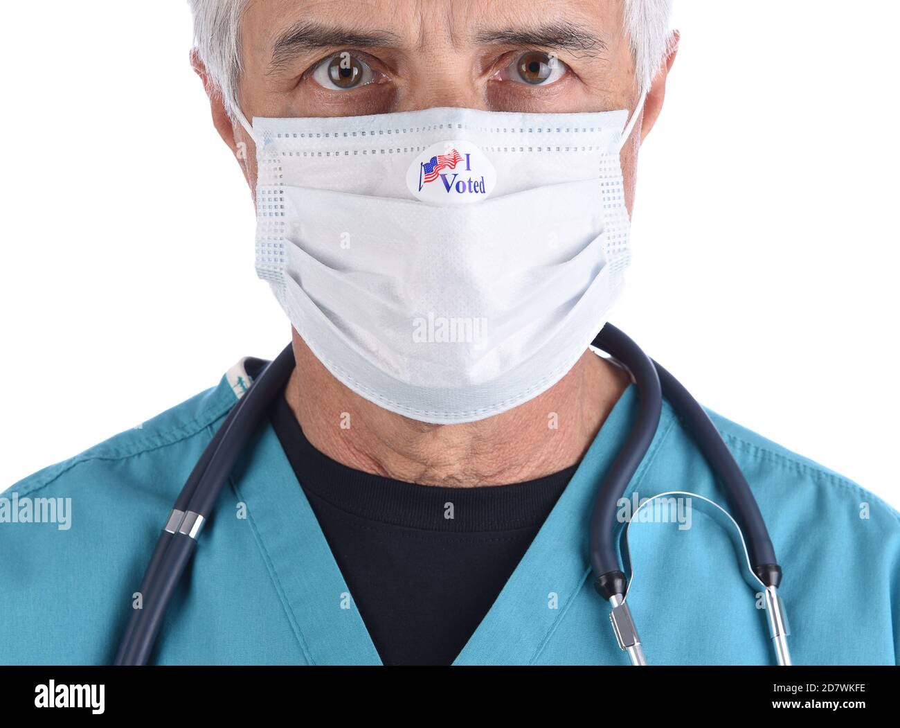 Closeup of a doctor with an I Voted sticker on the COVID-19 protective mask he wore to vote. The man is wearing surgical scrubs with a stethoscope. Stock Photo