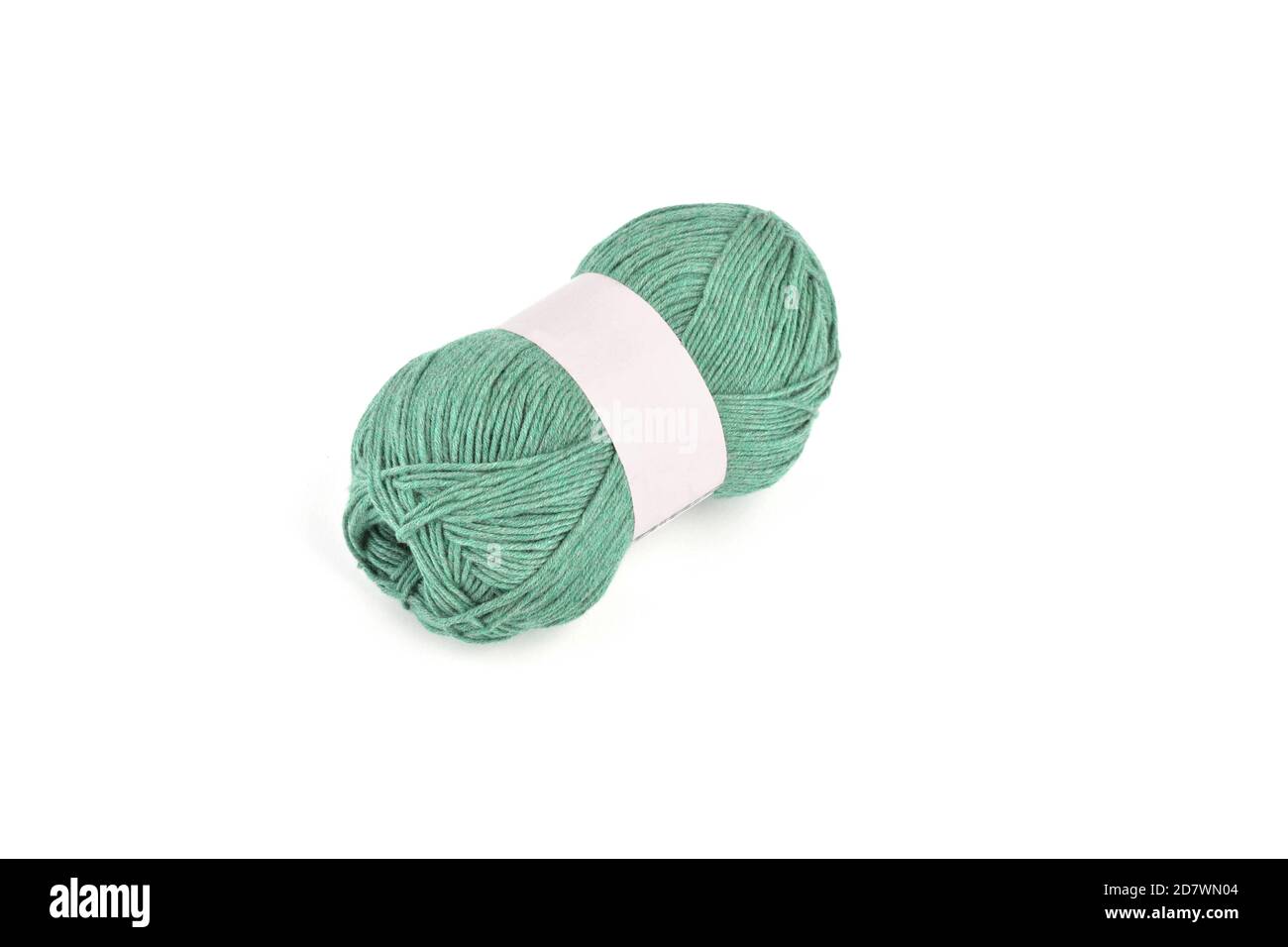 Tangle of green color yarn with blank label on white background skein