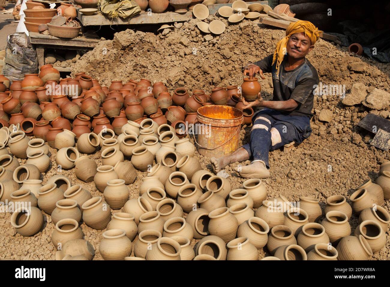 A potter adding glaze to pots in the old city of Delhi Stock Photo