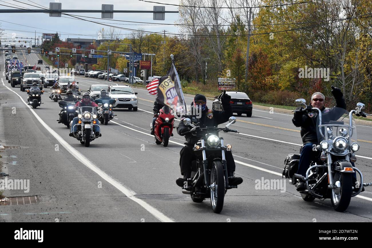 A motorcyclist riding while waving a flag during the campaign rally.A few supporters of President Donald Trump held a 20 mile Road Rally through Luzerne County which was always a democrat strong hold until the 2016 election when it surprisingly switched to Republican. Stock Photo