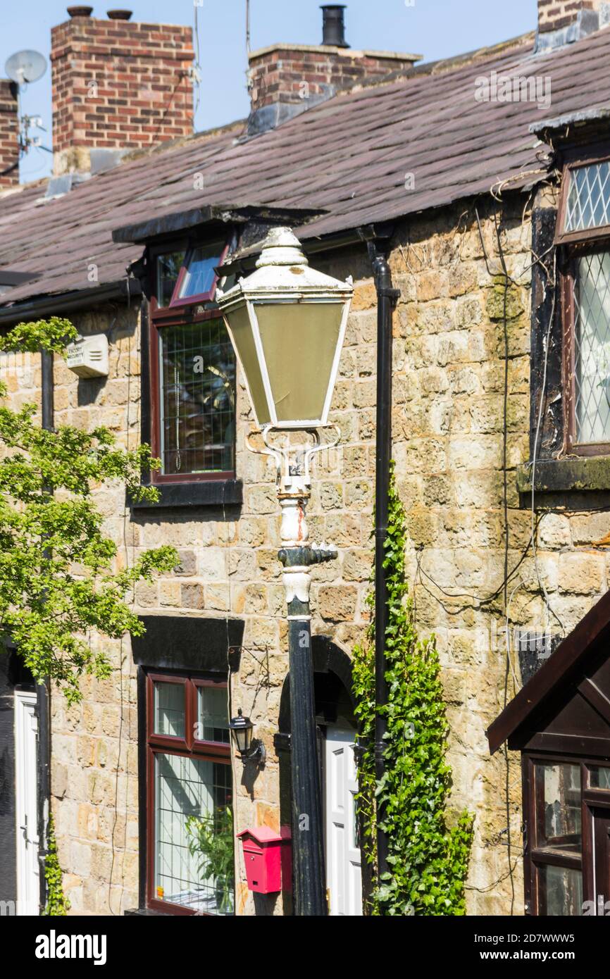Former gas street light outside stone cottages dating from the early part of the 19th century on Greenside, Farnworth, on the edge of Farnworth park. Stock Photo