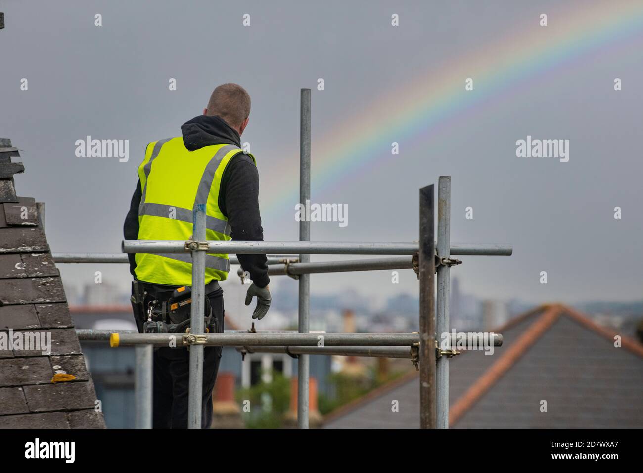 A rainbow behind scaffolders as they prepare scaffolding high up over London Stock Photo
