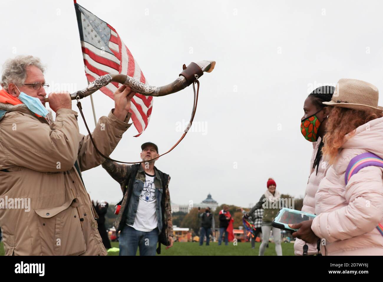 A man blows a Shofar as other demonstrators listen at a "Hold the Line" "worship protest" hosted by Christian musician Sean Feucht, on the National Mall in Washington, U.S., October 25, 2020. REUTERS/Cheriss May Stock Photo
