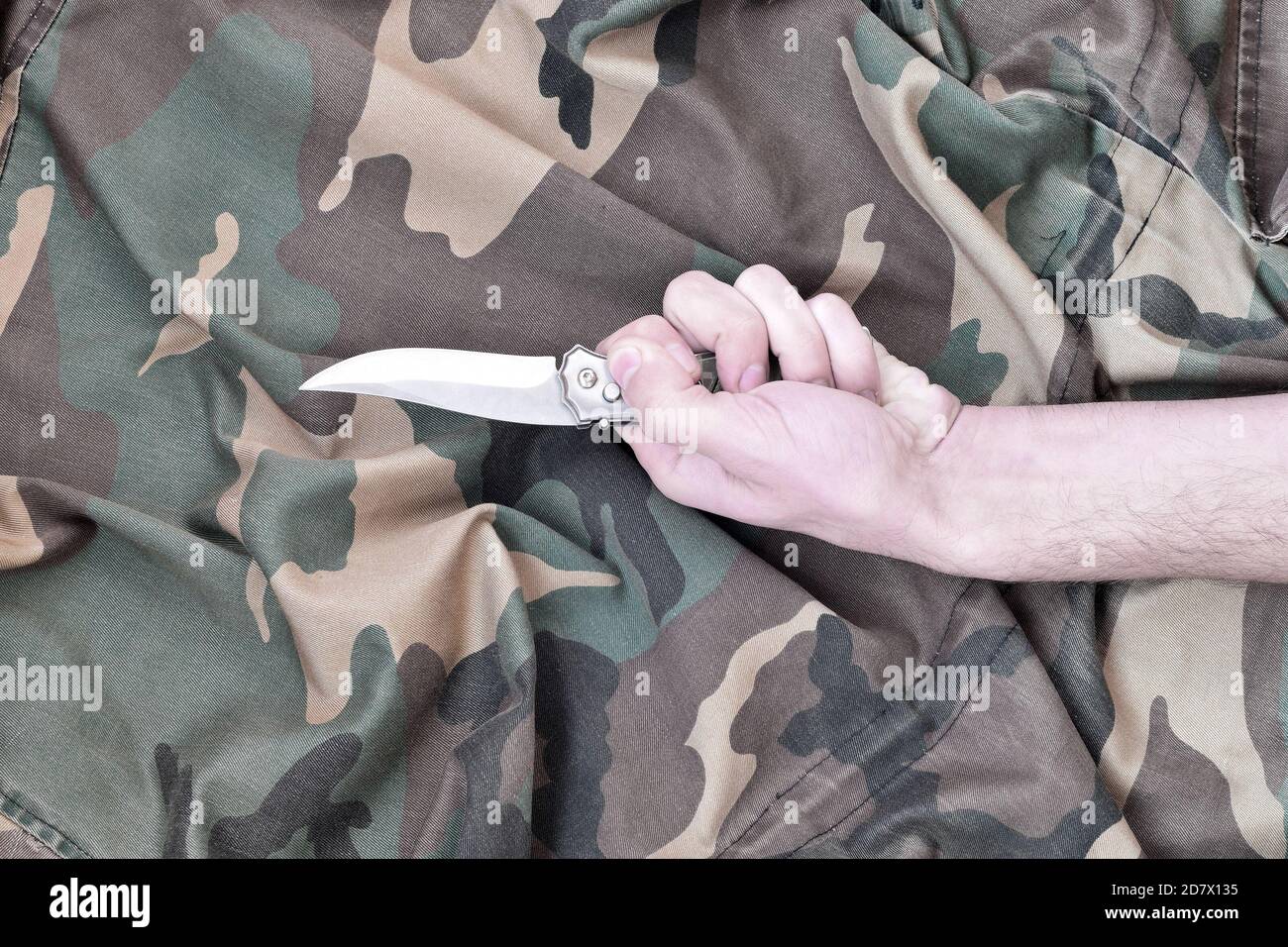 Hand in tactical glove, holding folding knife, on white background Stock  Photo - Alamy