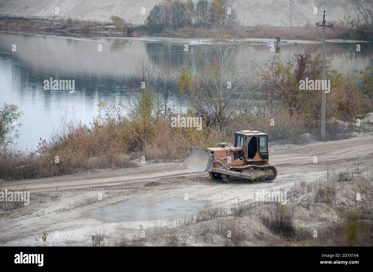 Quarry aggregate with heavy duty machinery on Construction industry. Caterpillar loader Excavator with backhoe driving to construction site quarry Stock Photo