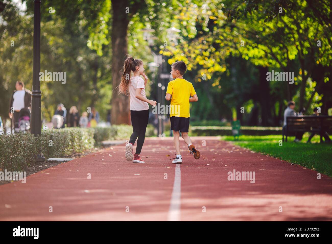 Child fitness, twins kids running on stadium track in city park , training and children sport healthy lifestyle. Outdoor activities by running make Stock Photo