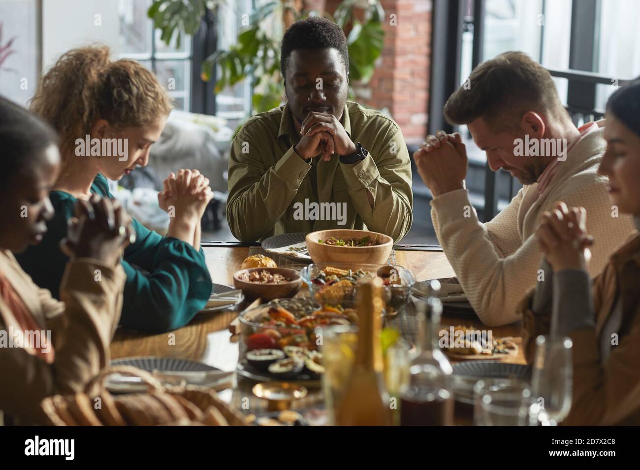 Portrait of African-American man praying with eyes closed while sitting