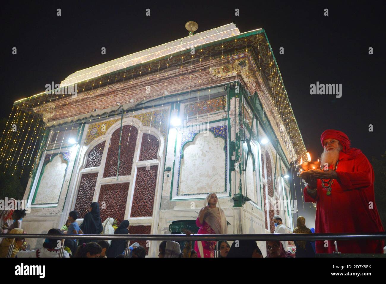 Pakistani Muslim devotees light candles and earthen lamps at the shrine of famous fifteenth century Sufi Saint Hazrat Mir Mohammed Muayyinul during 397th URS celebrations in Lahore. Thousands of people across the country visit the shrine to pay tribute to him during a three-day festival.The saint was equally popular among the Muslim and Sikh religions, as Mian Mir went to Amritsar(India) in December 1588 to lay the foundation stone of Sikhs holiest site, the Golden Temple, which is commonly known as Sri Harminder Sahib. (Photo by Rana Sajid Hussain/Pacific Press) Stock Photo