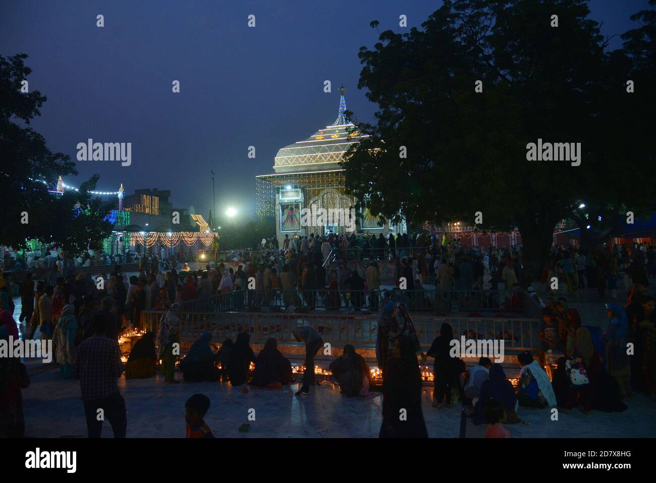 Pakistani Muslim devotees light candles and earthen lamps at the shrine of famous fifteenth century Sufi Saint Hazrat Mir Mohammed Muayyinul during 397th URS celebrations in Lahore. Thousands of people across the country visit the shrine to pay tribute to him during a three-day festival.The saint was equally popular among the Muslim and Sikh religions, as Mian Mir went to Amritsar(India) in December 1588 to lay the foundation stone of Sikhs holiest site, the Golden Temple, which is commonly known as Sri Harminder Sahib. (Photo by Rana Sajid Hussain/Pacific Press) Stock Photo