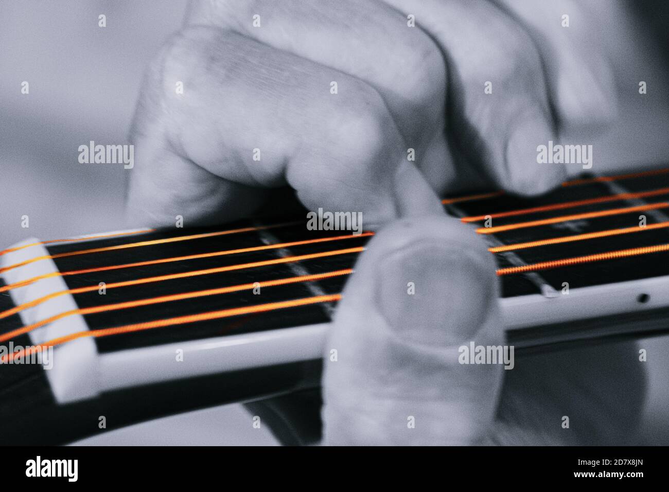 Close up on guitar player with hands on the fretboard, fingerboard, in chord position. Stock Photo