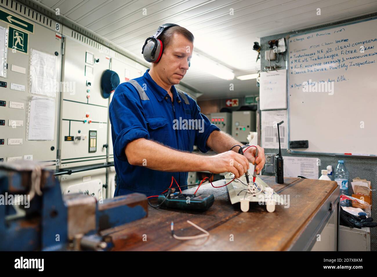 Marine electrical engineer officer in engine control room ECR. He works in Stock Photo
