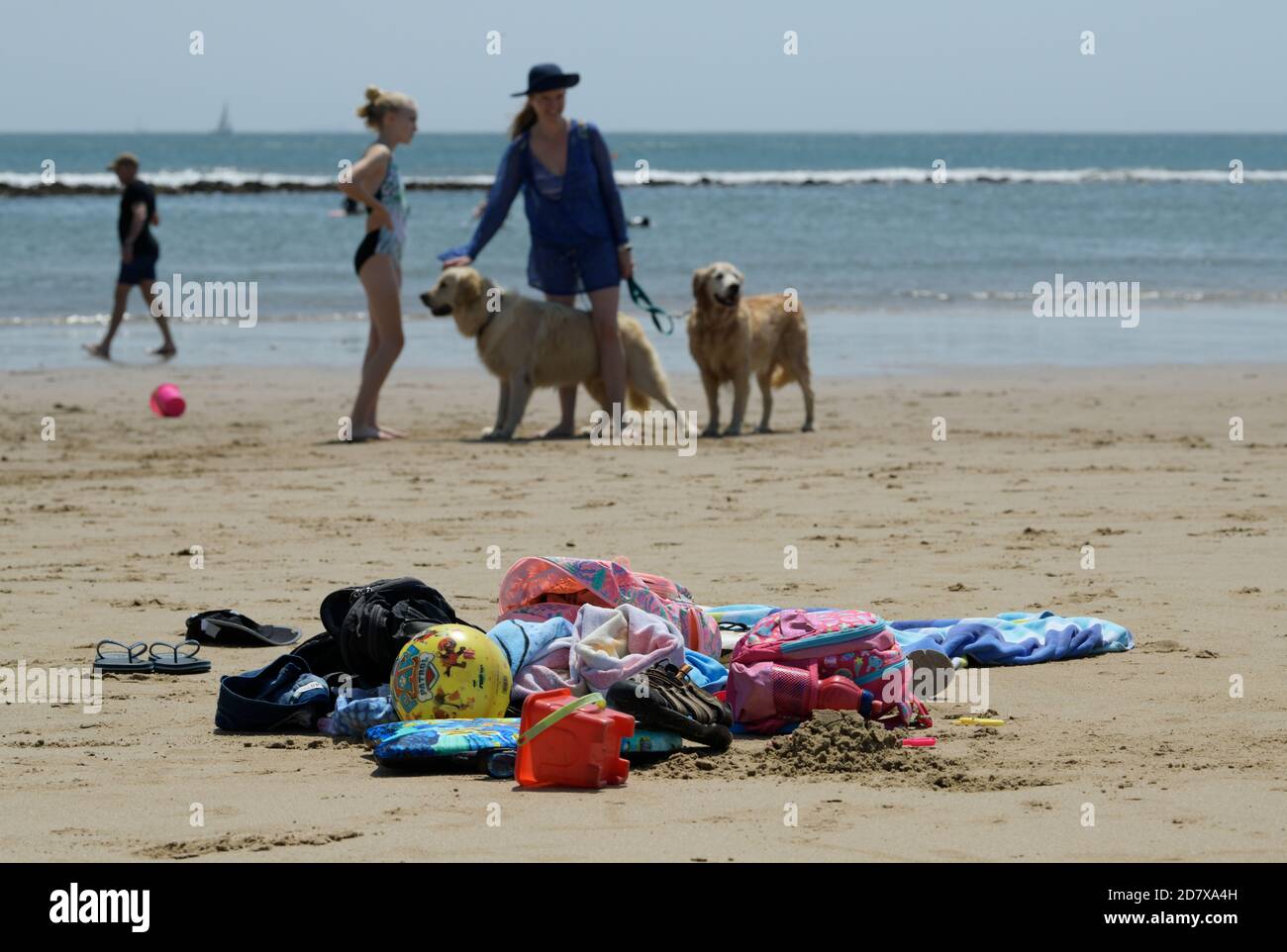 Objects, towels and toys on beach, woman walking dogs, seaside activities, active lifestyle, Durban, South Africa, Golden Mile waterfront, girl Stock Photo