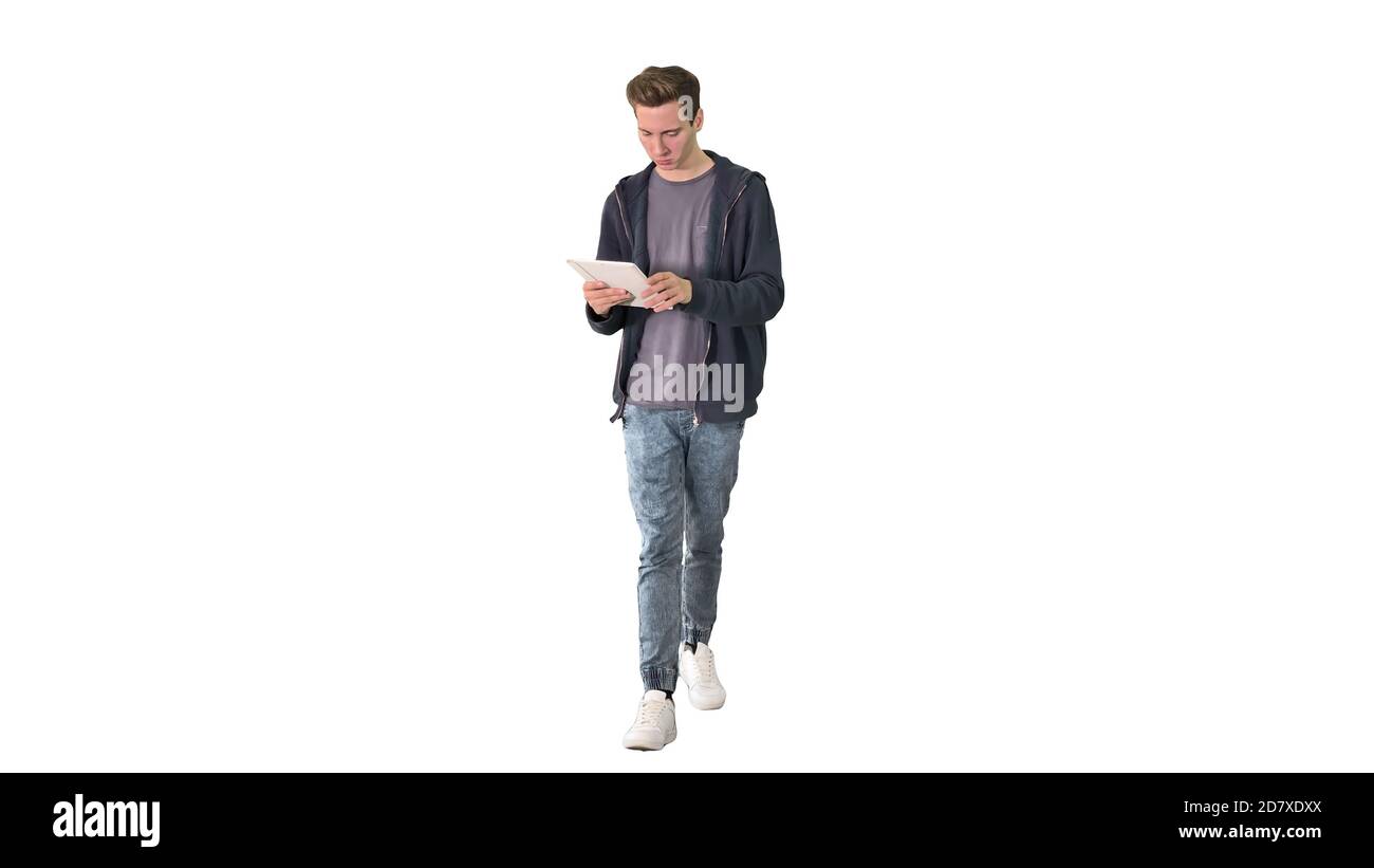 Casual man using tablet while walking on white background. Stock Photo