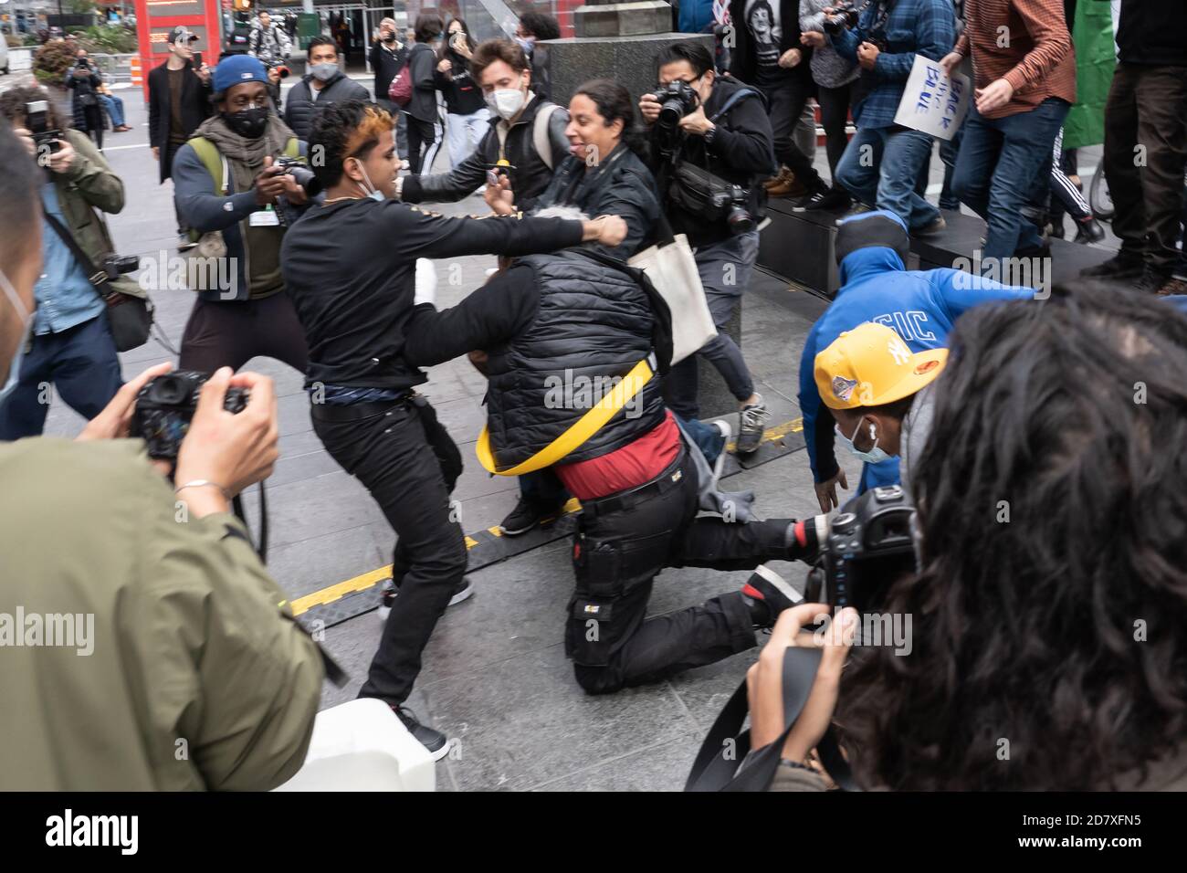 NEW YORK, NY – OCTOBER 25: Anti-Trump and Pro-Trump protesters fight in Times Square on October 25, 2020 in New York City. Stock Photo