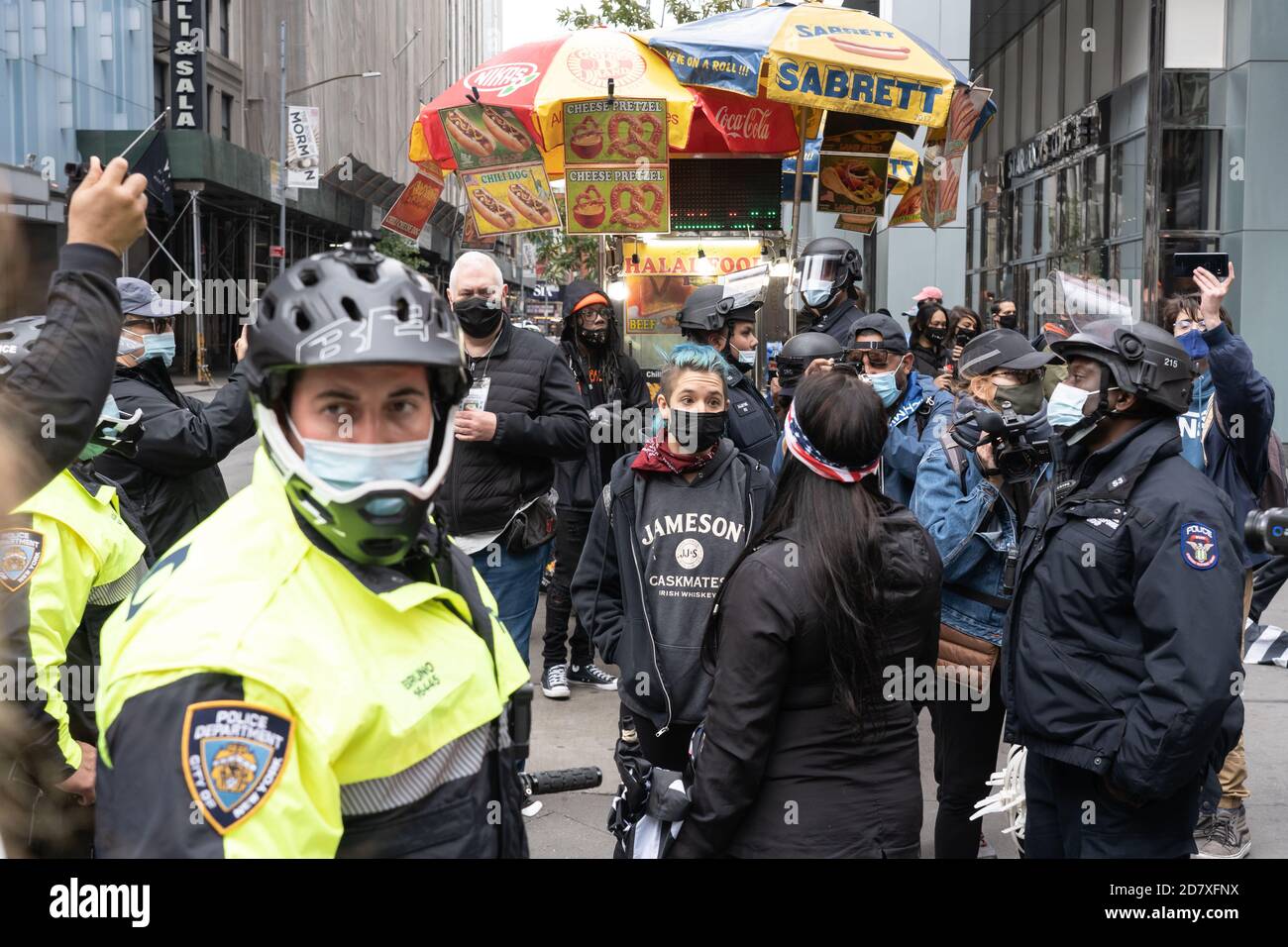 NEW YORK, NY – OCTOBER 25: Anti-Trump and Pro-Trump protesters talk as police watch over in Times Square on October 25, 2020 in New York City. Stock Photo