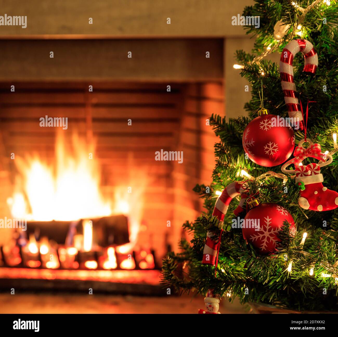 Burning fireplace, christmas time. Cozy warm home, xmas tree decorated, wood logs fire glowing