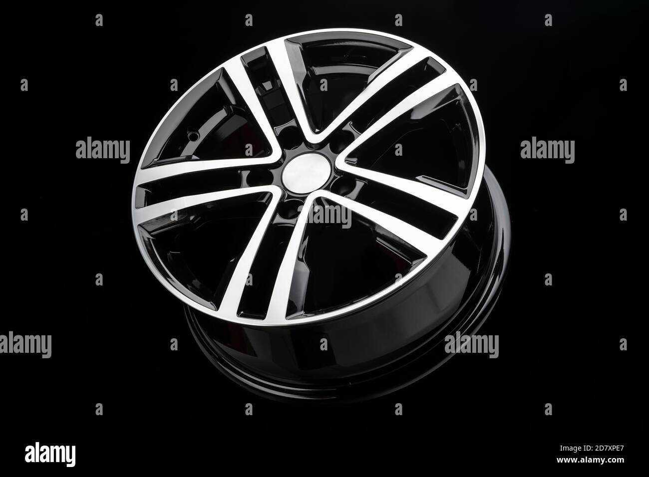 new shiny alloy wheel, color black with silver front. Dark background, side view Stock Photo Alamy