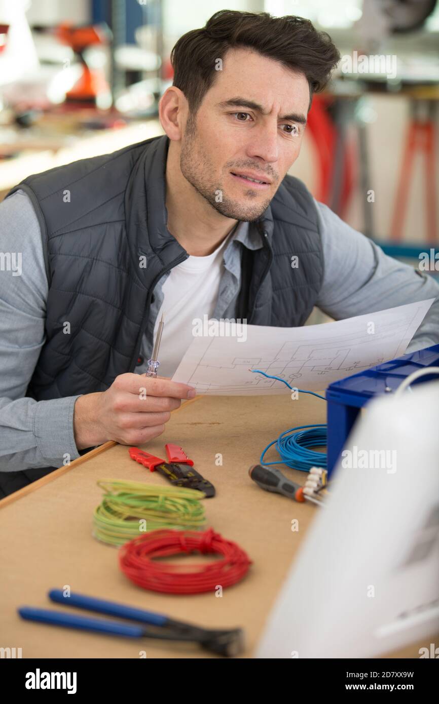 puzzled technician reading wiring instructions Stock Photo Alamy