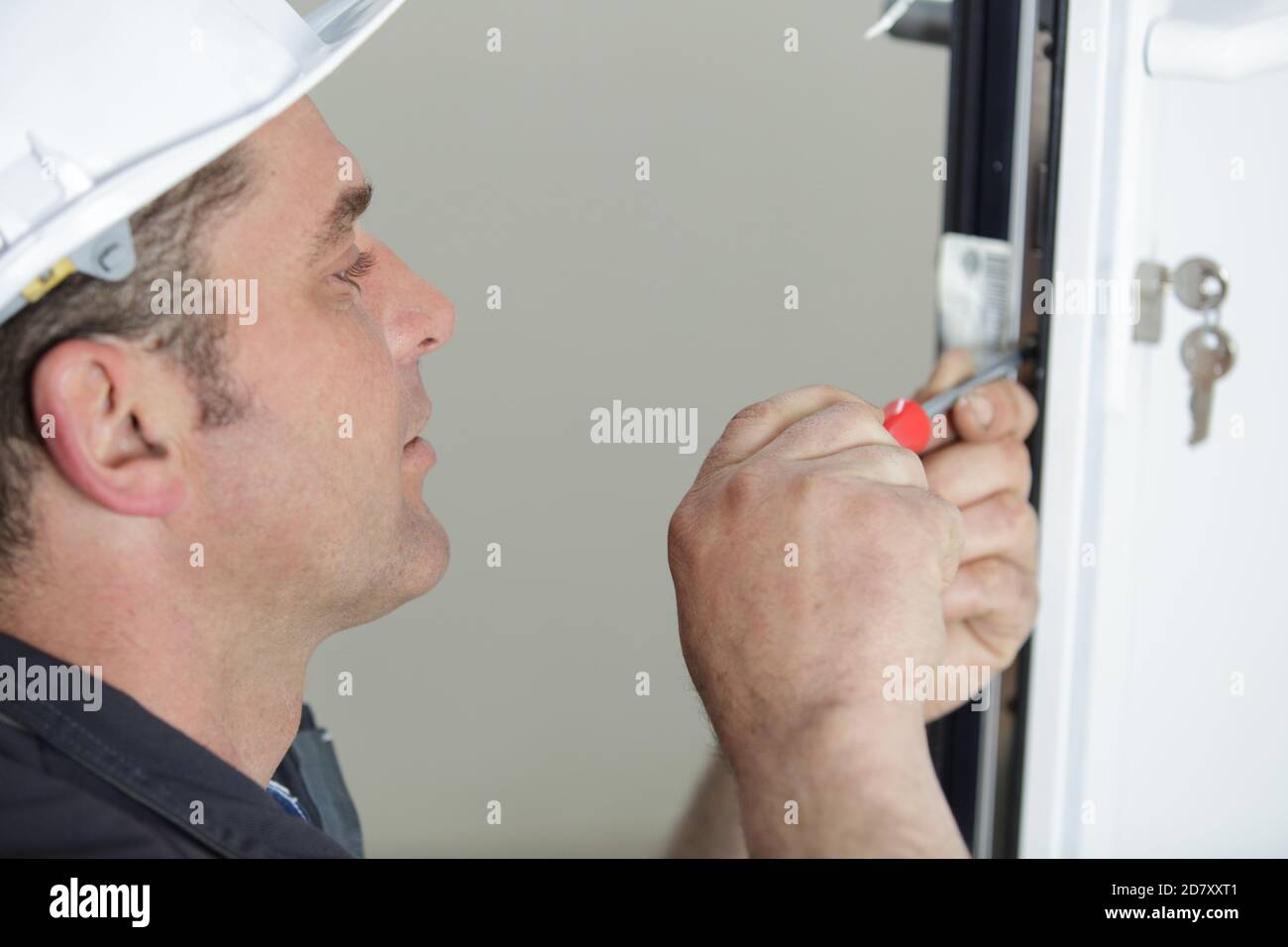 worker fasten a handle to a plastic window Stock Photo