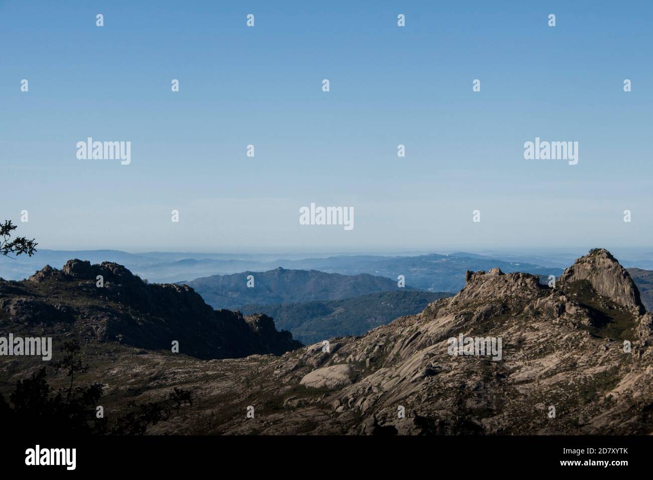 Mountain shapes and curves fade away in the horizon under the morning fog Stock Photo
