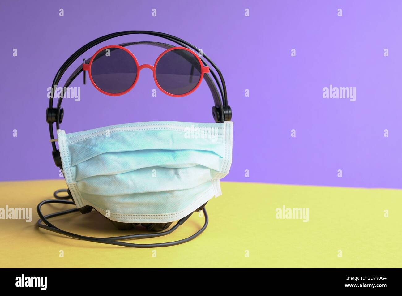 Head phones wrapped with face mask and sun glasses. Wear a mask concept. Stock Photo
