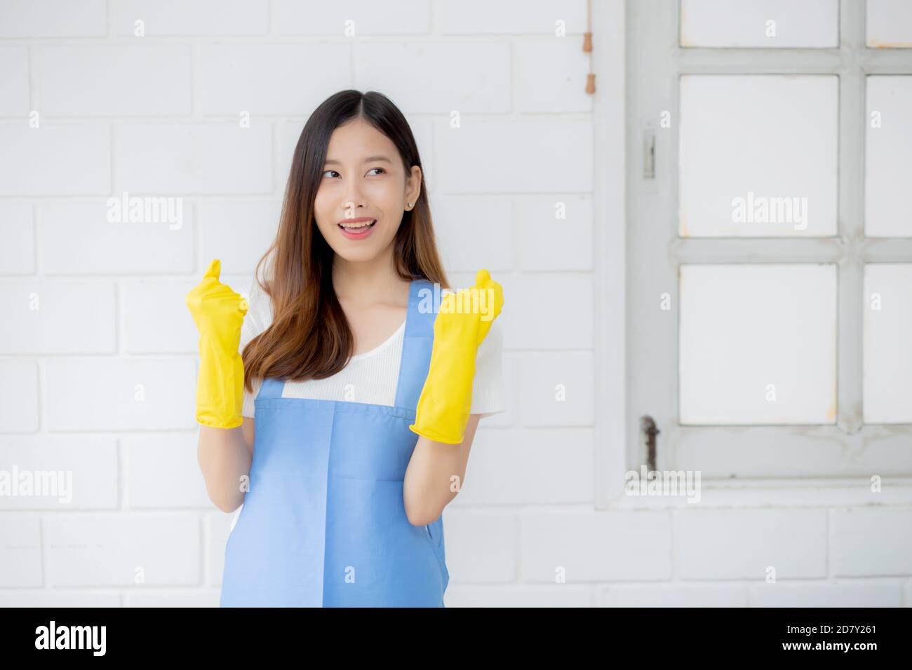 Portrait young asian woman is housekeeper in rubber gloves and apron ...