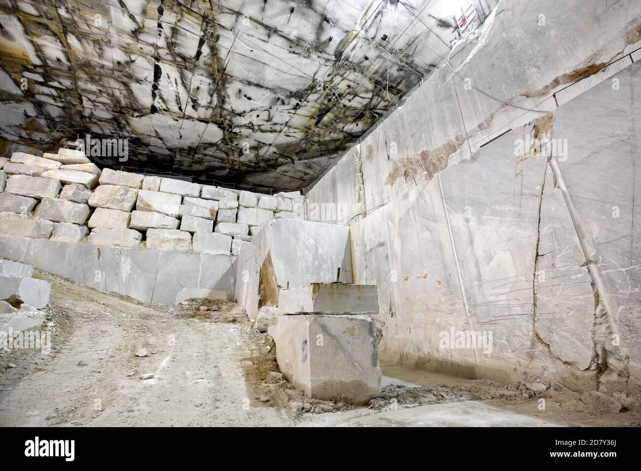 Panorama view of the rock face and cut blocks of marble in an open cast quarry or mine in Carrara, Tuscany, Italy during extraction of the rock from a Stock Photo