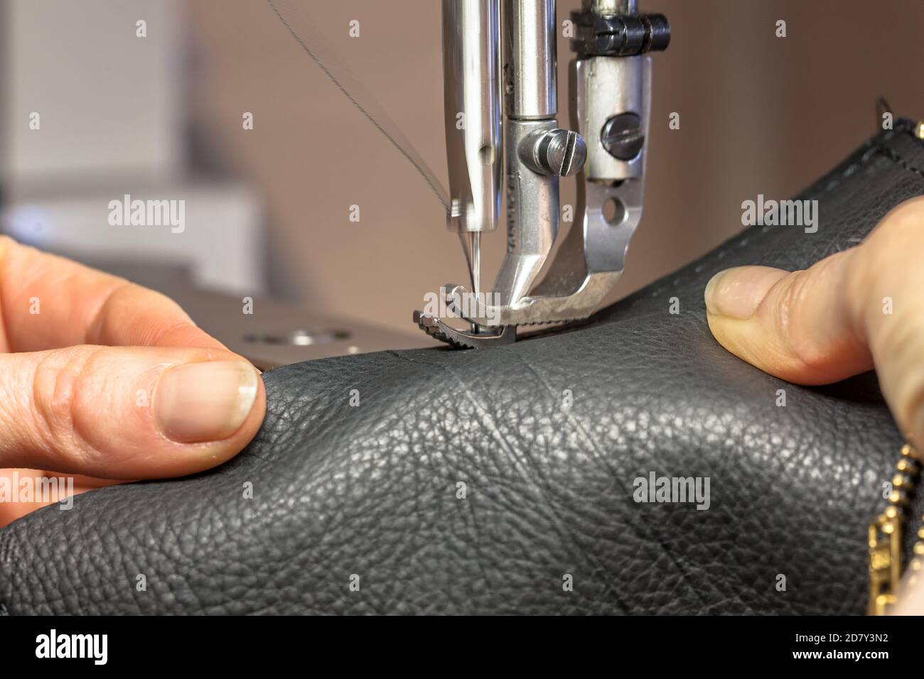 Leather Sewing machine in action in operated with hands