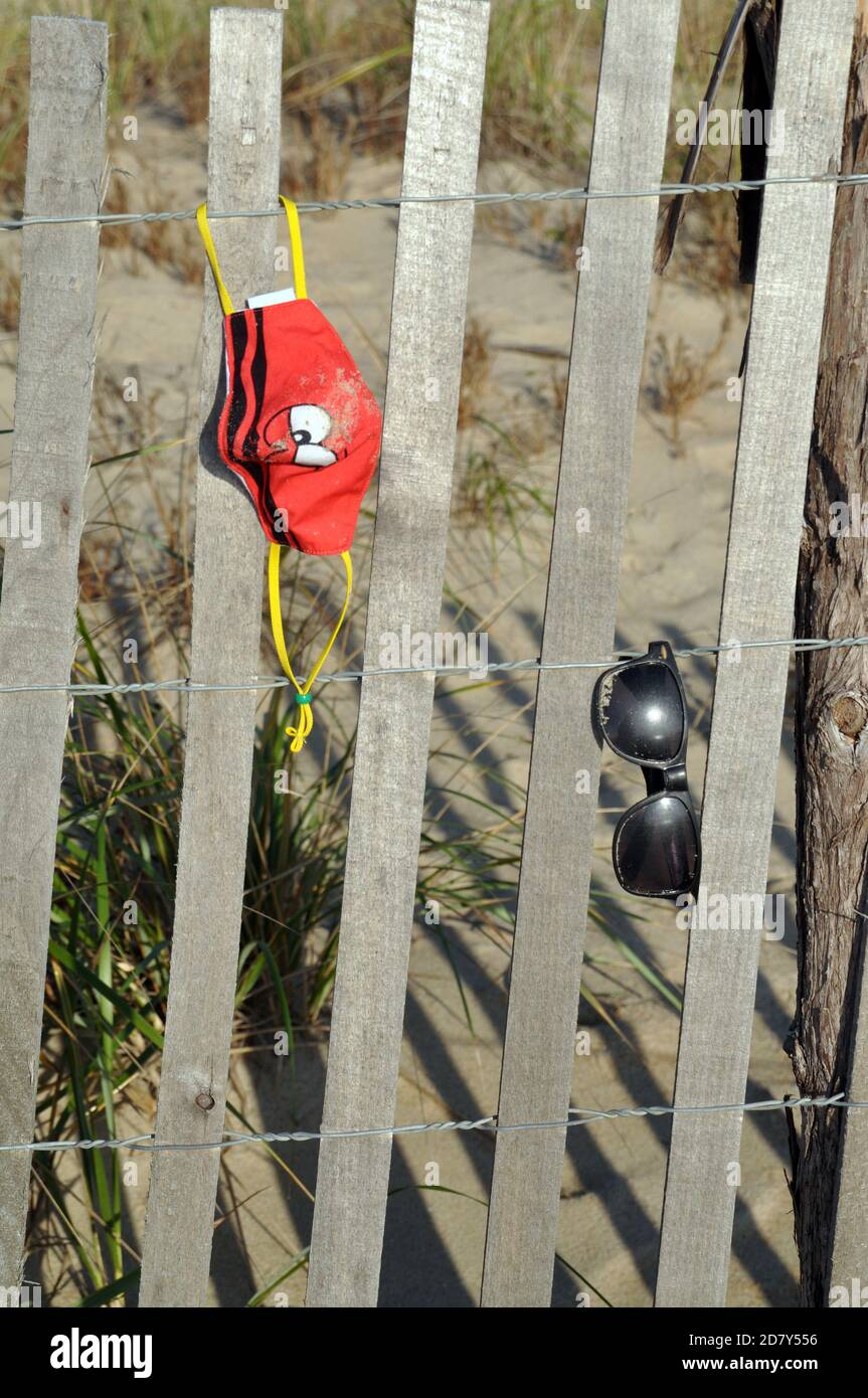 Childs mask hanging on a beach fence Stock Photo