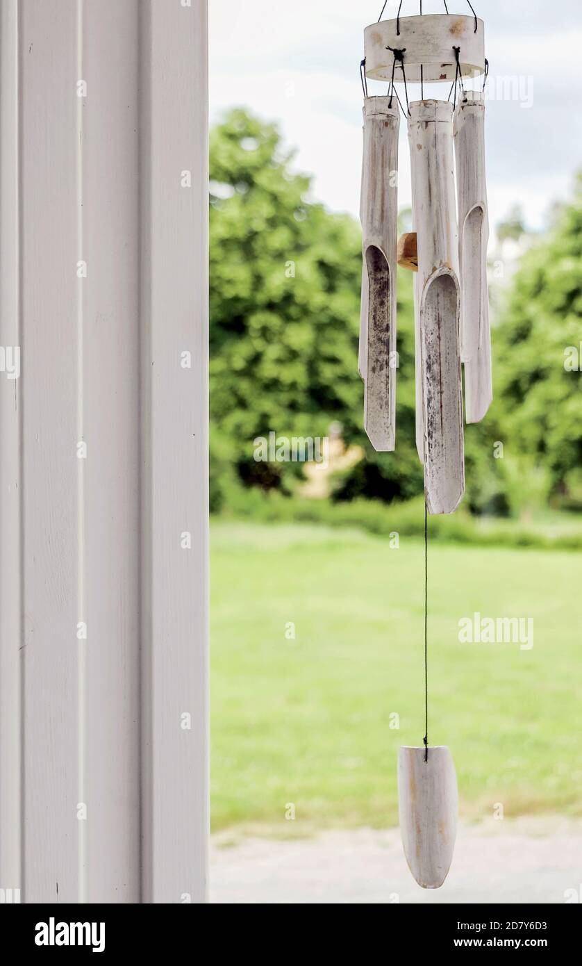 white wooden wind chime with green garden Stock Photo Alamy