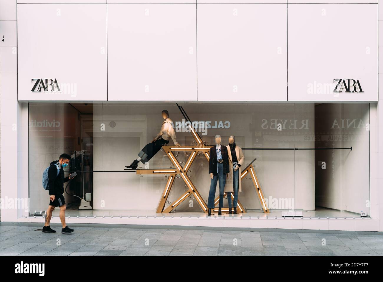 Madrid, Spain - 3rd October, 2020: Shop window of Zara fashion store on Preciados Street. Young man wearing face mask walking by Stock Photo