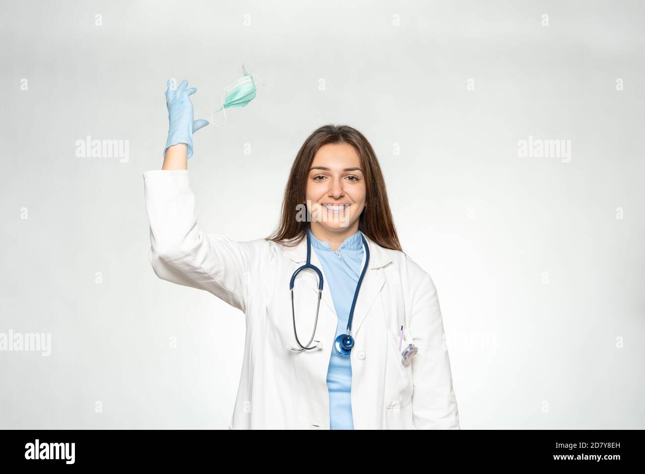 Smiling female young european doctor throw away mask after successfully defeating the coronavirus. Stock Photo