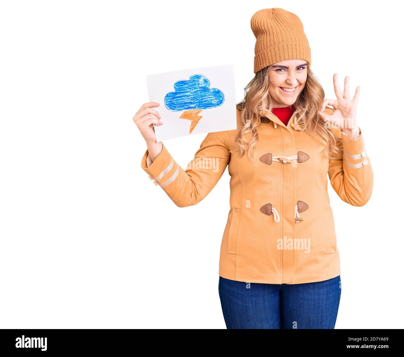 Young caucasian woman holding thunder draw doing ok sign with fingers, smiling friendly gesturing excellent symbol Stock Photo