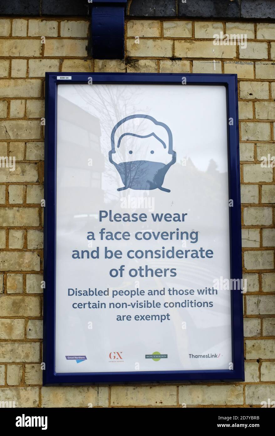 A railway station sign about wearing a face covering on trains, England Stock Photo