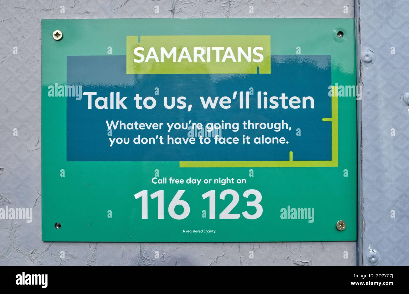 A rail station sign with a help number for the Samaritans, England Stock Photo