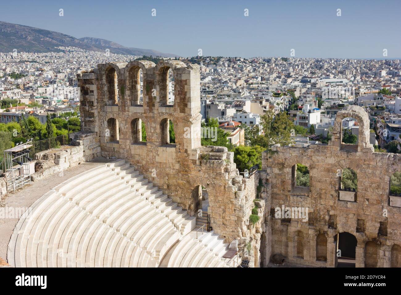 View of the Greek ruins of Dionysus Theatre with the city of Athens seen behind on a sunny day with blue sky. Stock Photo