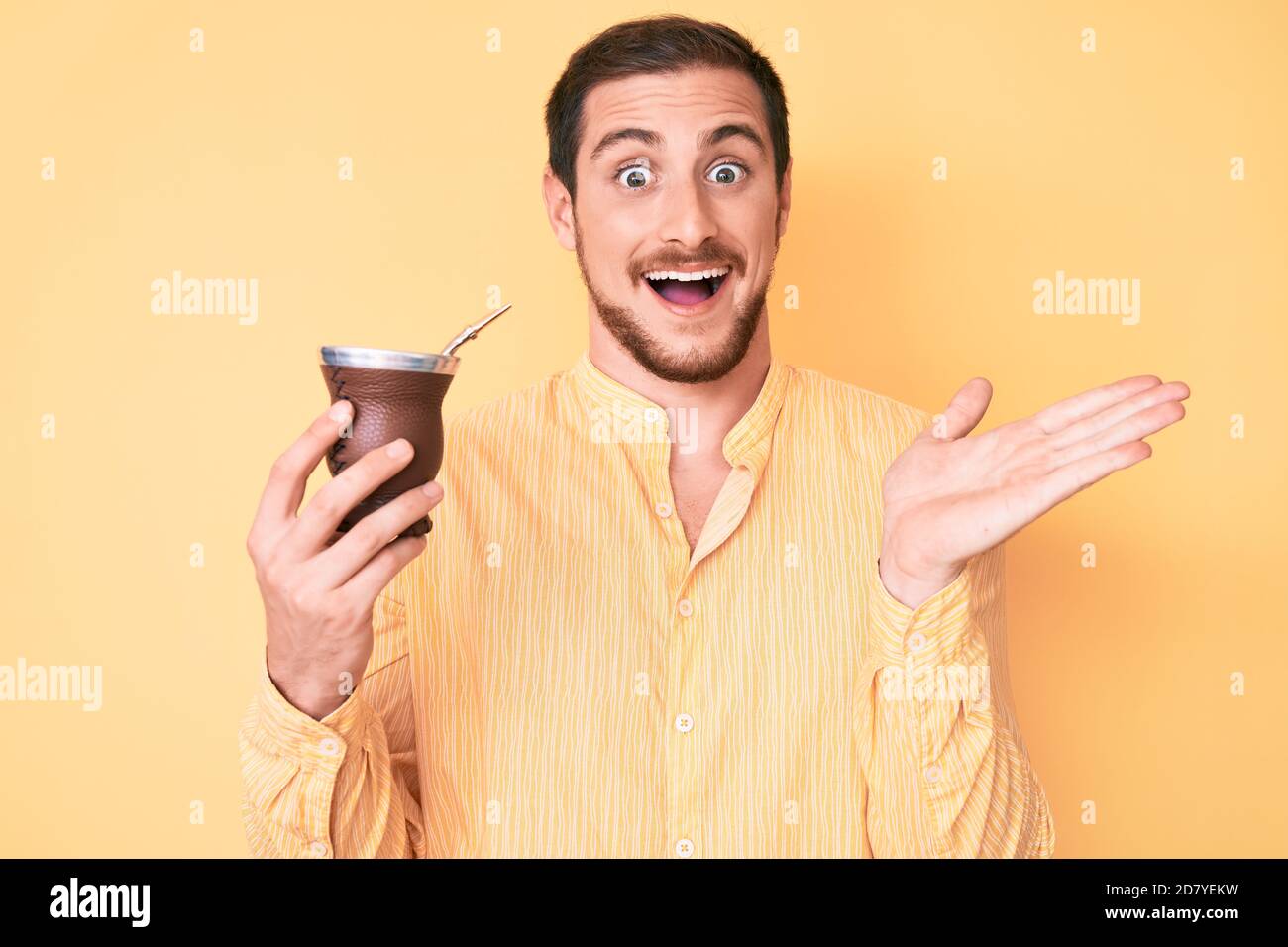 Young handsome man drinking mate infusion celebrating achievement with ...