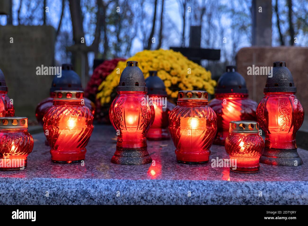 Candle lights in the evening on cemetery grave, All Saints Day holiday, Christian tradition. Stock Photo