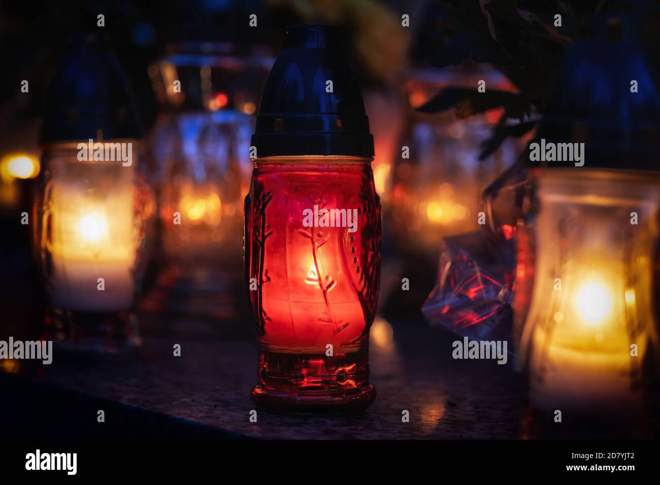 Ethereal candle lights lit on All Saints Day night, Christian tradition, selective focus, shallow depth of field. Stock Photo