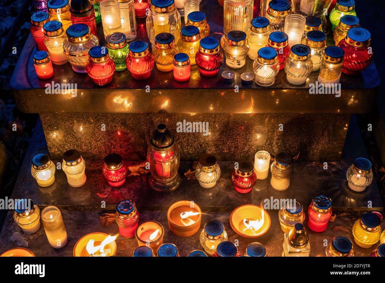 Candle lights at night on cemetery grave on All Saints Day, Christian tradition. Stock Photo