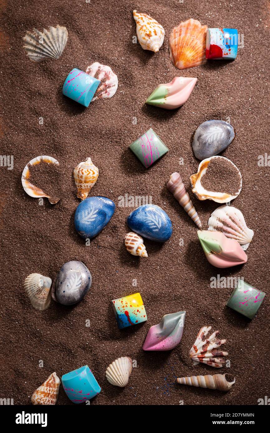 Overhead view of chocolate candies and sand Stock Photo - Alamy