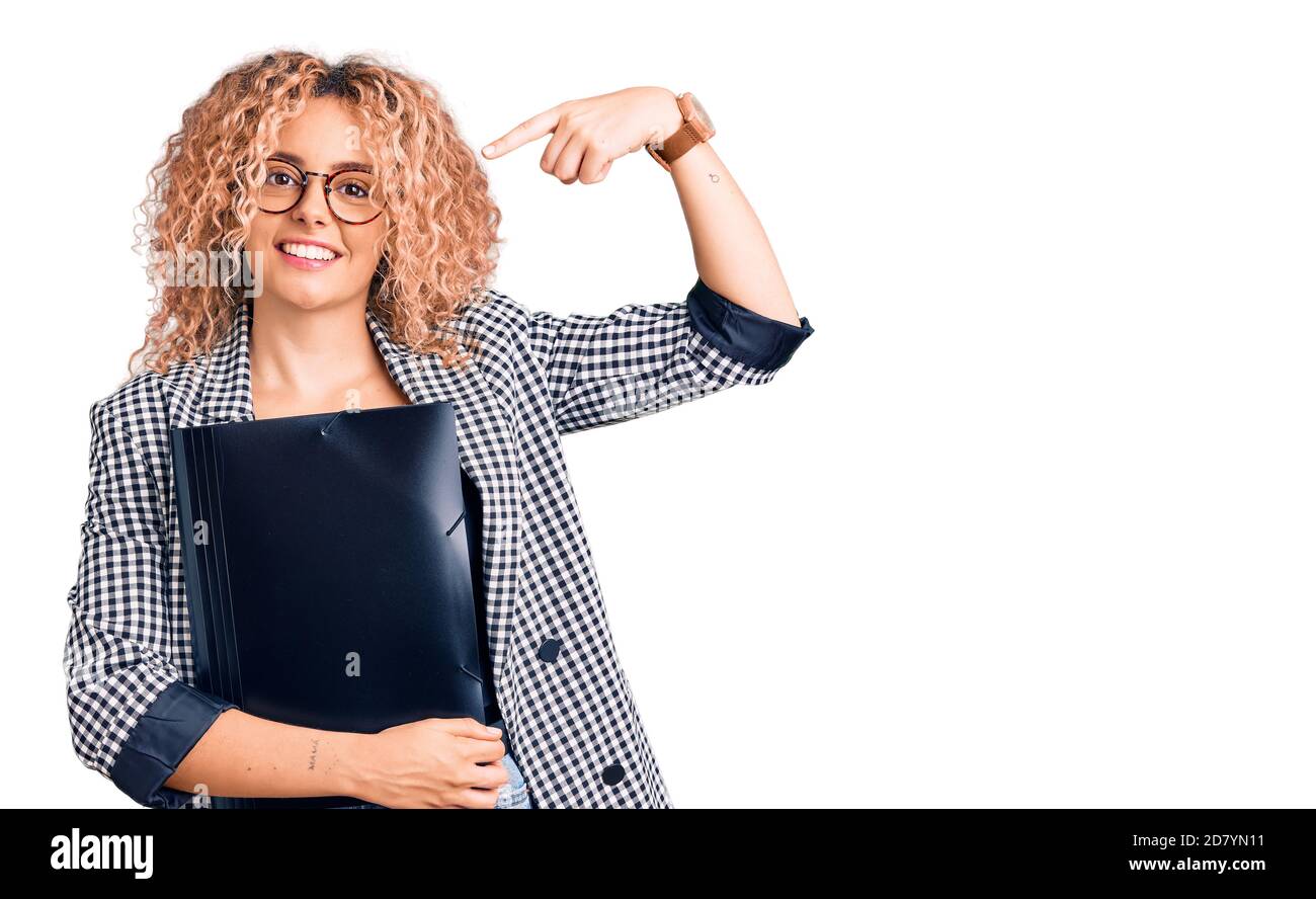 Young blonde woman with curly hair holding business folder pointing ...