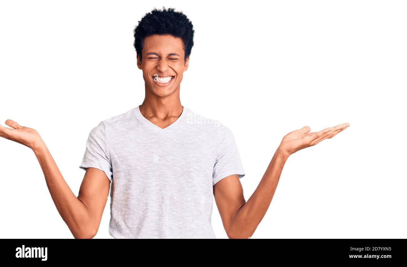 Young african american man wearing casual white t shirt celebrating mad ...