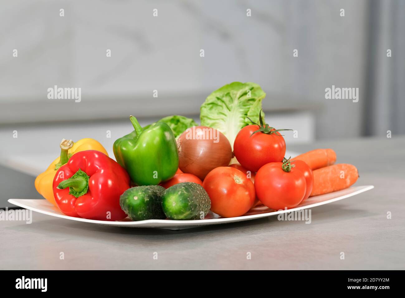 Close up of an assortment of fresh vegetables on a plate on an out of focus background. Fresh food and vegetables concept. Stock Photo