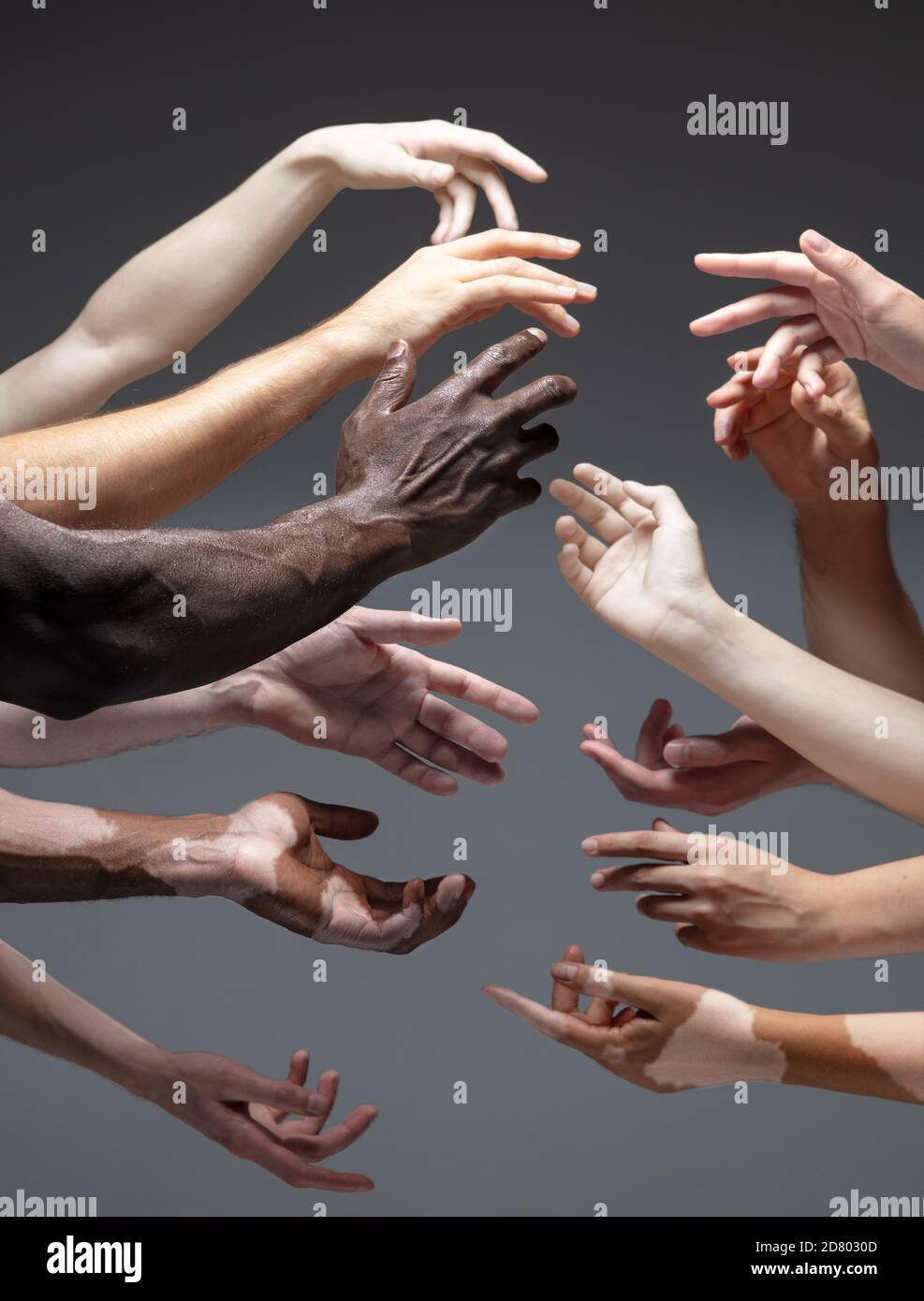 Humanity. Hands of different people in touch isolated on grey studio