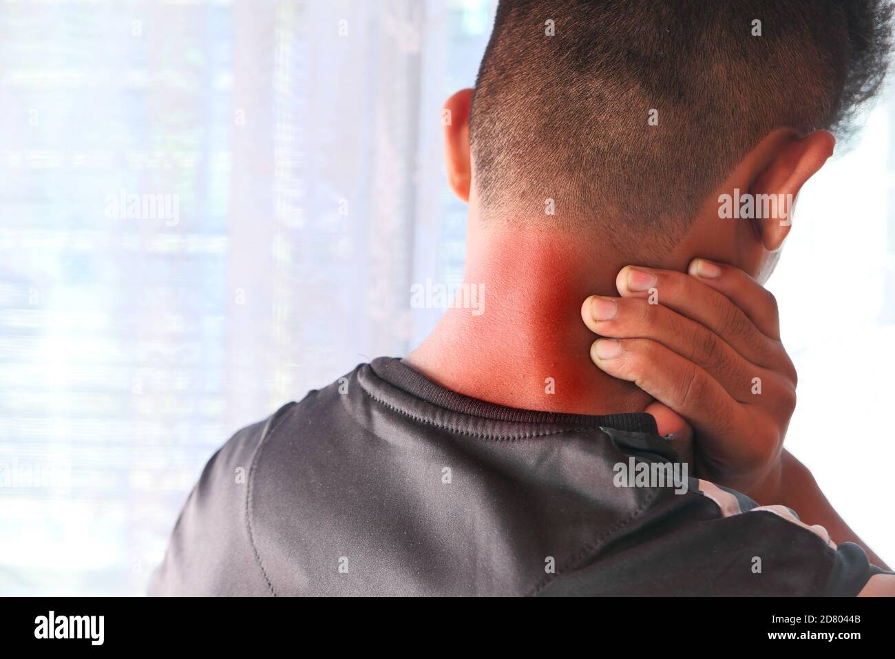 man suffering from neck pain at home. Stock Photo
