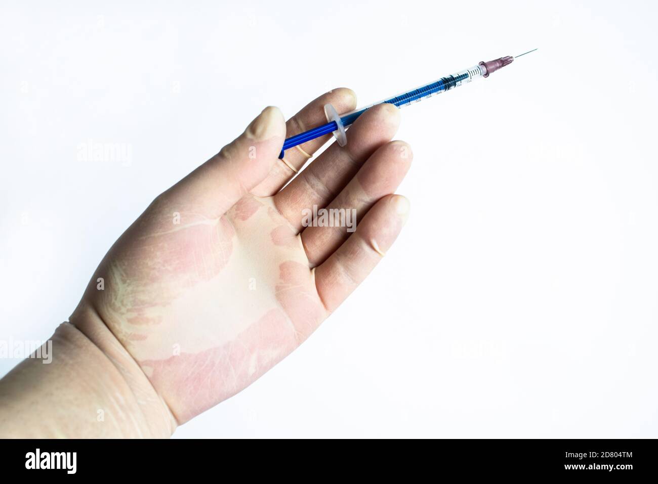 In the hand of rubber gloves hold a syringe Stock Photo