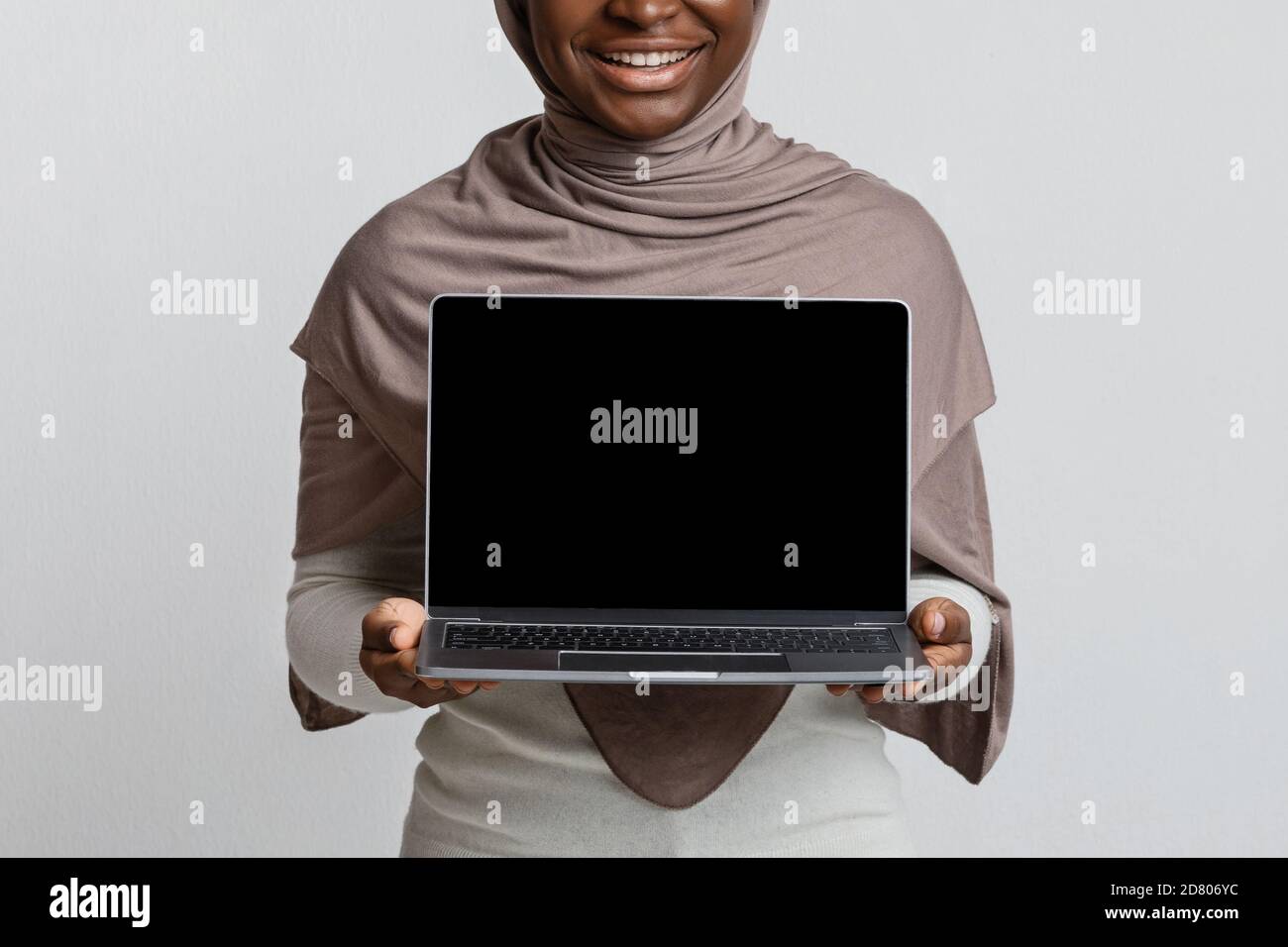 Download Mockup Of African Muslim Lady In Hijab Holding Laptop With Black Screen Stock Photo Alamy