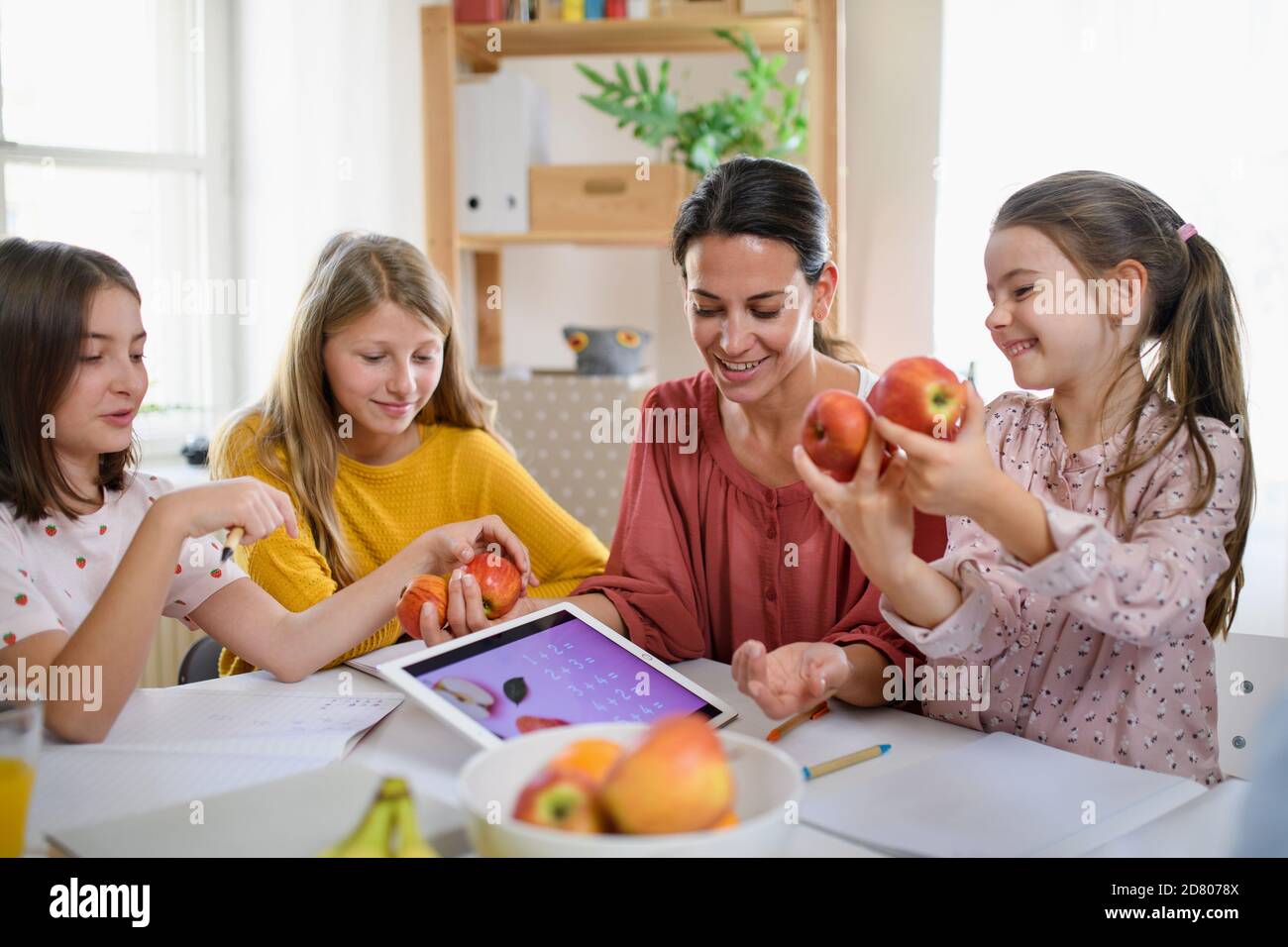 Group of homeschooling children with teacher studying indoors, coronavirus concept. Stock Photo