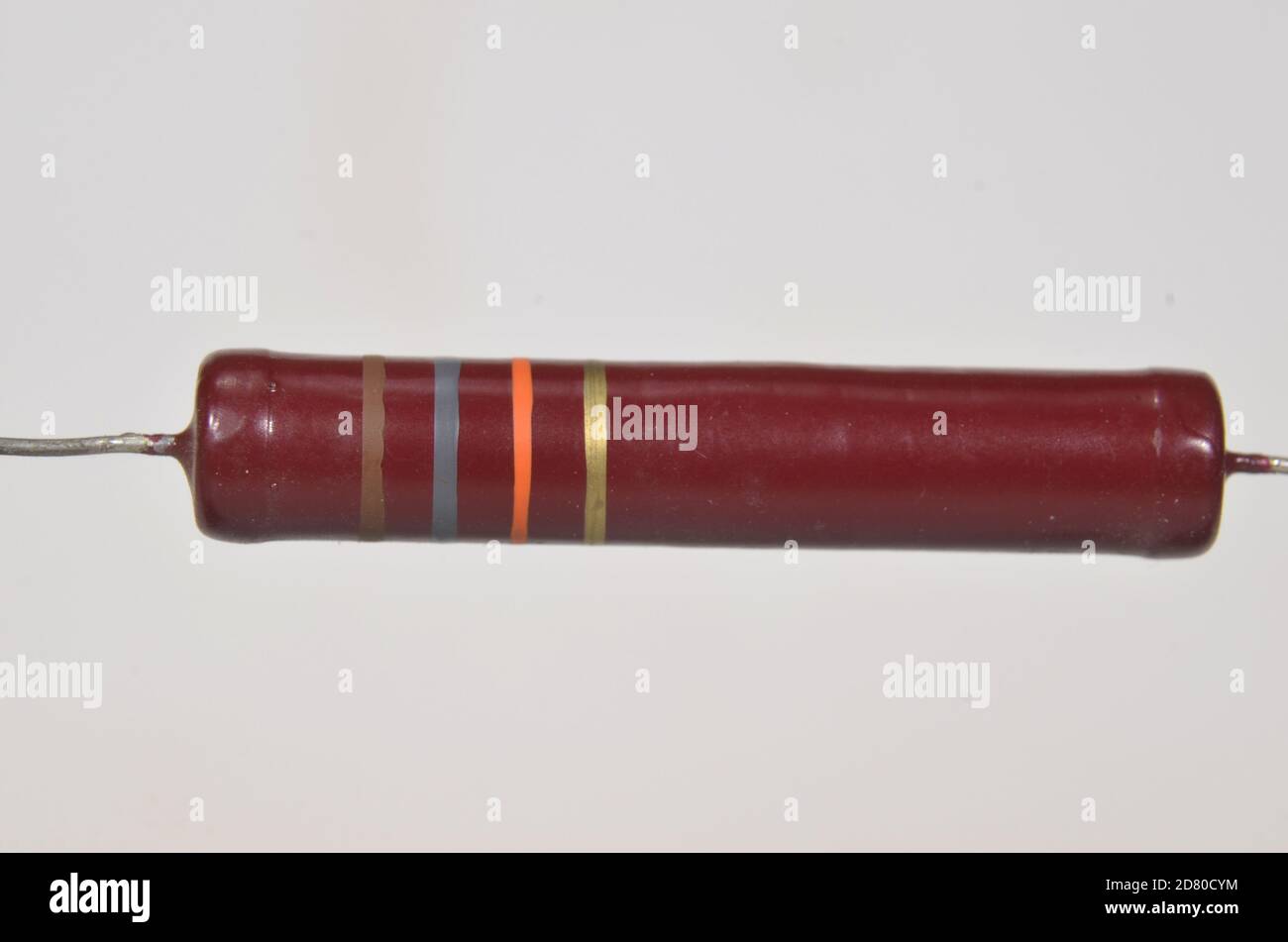 Closeup on single electronic resistor. Color bands tell us that the reistance of this component is 18kOhm with a tolerene of 5% Stock Photo